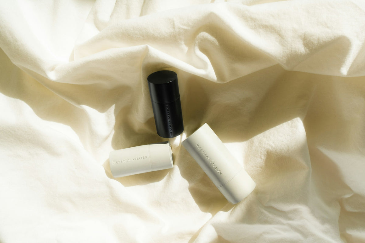 Minimal white bottles resting on soft cloth – the Vesper guide to choosing a lubricant